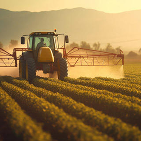 Tractor spraying pesticides on farm