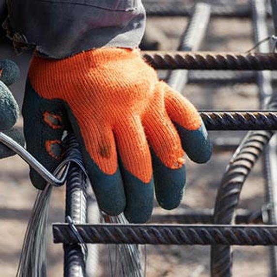 Worker using steel tying wire to fasten steel rods to reinforcement bars