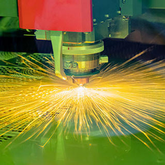 Close-up of the CNC laser cutting machine cutting the metal plate with the sparking light.