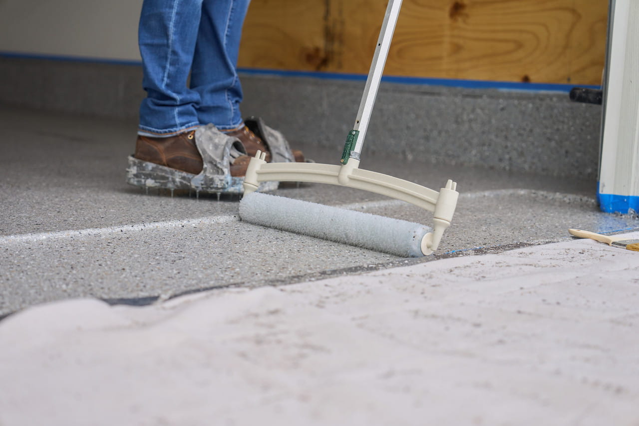 Contractor applying floor coating with roller