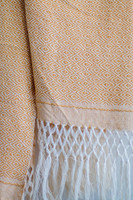 Golden Embrace Oaxacan Shawl in elegant yellow and white, worn as a statement piece for a chic look.  Make a statement with the handwoven Golden Embrace Oaxacan Shawl. This artisan-made accessory adds a touch of warmth and cultural flair in a vibrant yellow and white combo.