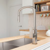 Live image of the brushed nickel Tono kitchen or laundry pull-out sink mixer by Fienza. Installed on a wooden bench with brushed nickel sink.