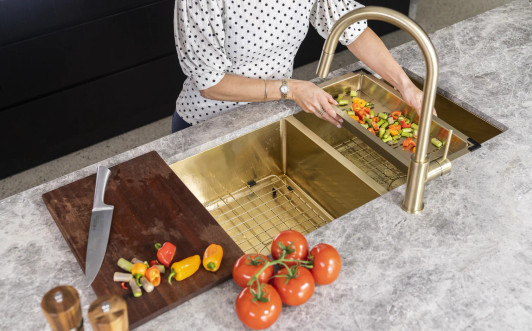 Lavello Kitchen Sink Colander - Liveimage in Brushed Bronze Gold, being used to wash vegetables.
