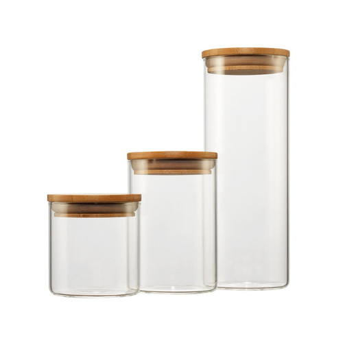 3 glass canisters with a wood lid placed side-by-side from smallest to tallest