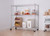 chrome shelving rack  in a kitchen storing a variety of dried goods and cooking tools