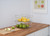 Two chrome wire baskets stacked on top of each other in a kitchen with items inside