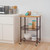 bronze kitchen cart filled with glass containers and canisters placed next to a kitchen cabinet