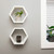2 white hexagon shelves with small planters