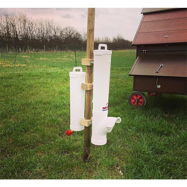 Dine-A-Chook enclosed hopper feeder and drinker mounted on a timber post beside a mobile coop