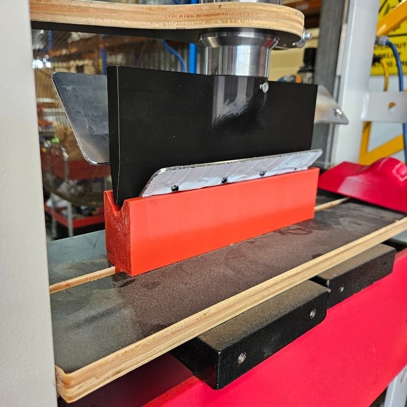 Aluminium bracket being folded on custom press jig in Dine-A-Chook Townsville workshop