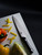 Shun Narukami Chef's Knife 8" (VSC0706) lying next to sliced peppers