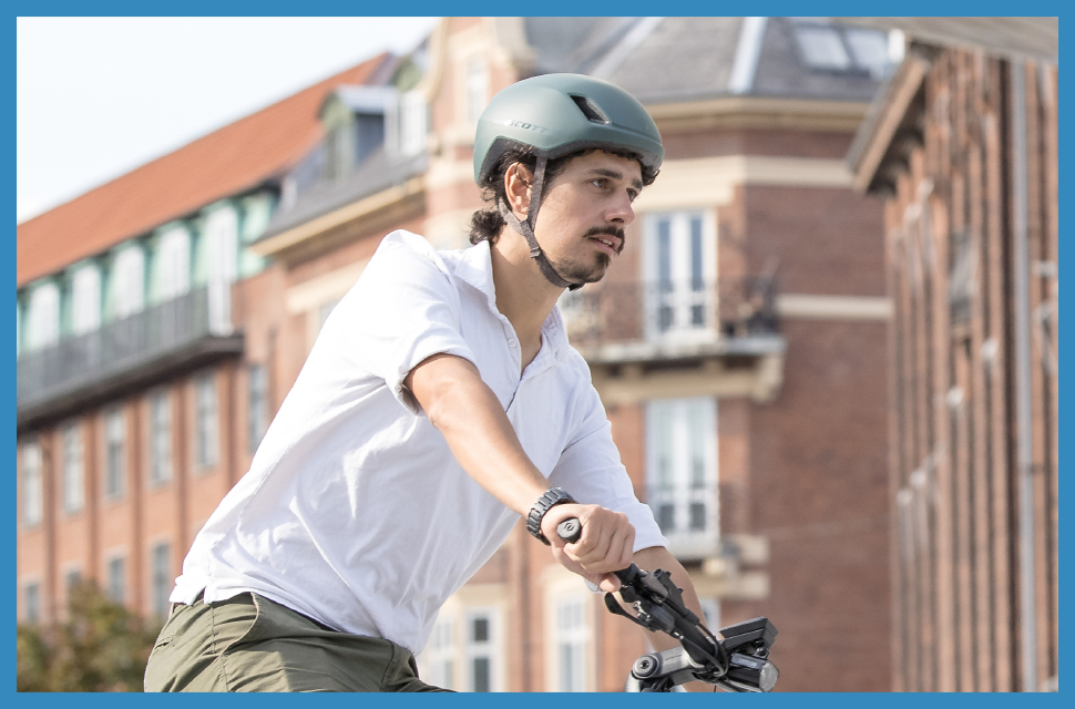 Man cycling in town wearing a cycling helmet - Eurocycles Ireland