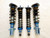 Flatout GR Lite coilovers set for Subaru vehicles, featuring four complete shock and spring assemblies with blue anodized hardware, linear springs, and upright rebuildable shocks