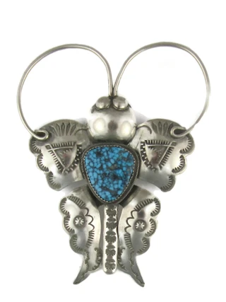 Handcrafted turquoise pendants resting on a polished wooden surface.