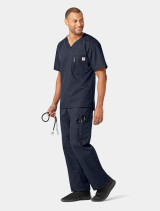 A top and pant full body view of a healthcare worker wearing the Carhartt mens scrub top C15108 in navy