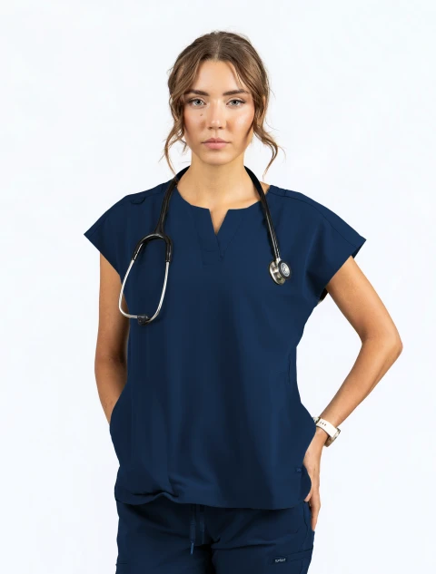 Medical professional wearing Spirit Scrubs navy blue dolman-sleeve scrub top (Style UOT115) untucked with a stethoscope around her neck.