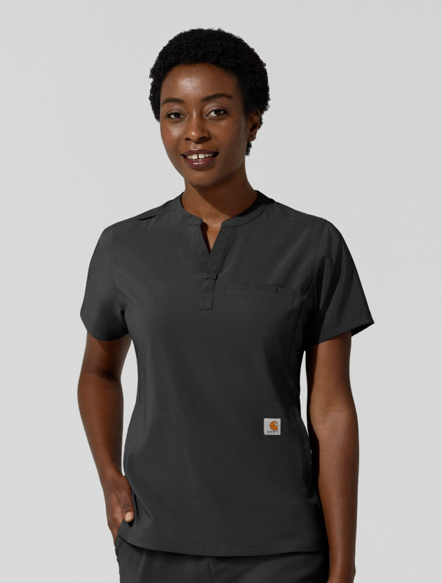 A female healthcare worker wearing the Carhartt women's chest pocket scrub top C13810 in black
