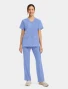 Full-length model view of Cherokee Workwear Originals Ultra Women's 2 Pocket Snap Front Scrub Top CK844A in Ciel