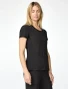 Side view of Med Couture Amp Women's Four Pocket Round Neck Scrub Top MC00027 in Black