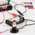 Exploring Electricity kit: a working circuit of batteries, lightbulb, and alligator clips with the bulb lit