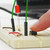 Finger pressing a button on a breadboard next to a working circuit, built with the Electronics Kit for Arduino