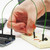 Hand plugging a resistor into a breadboard wired to an Arduino in the Electronics Kit for Arduino