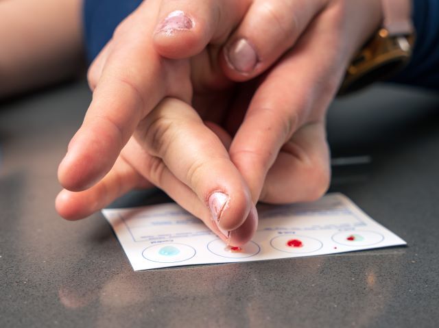 Person using home blood type test kit for health and education