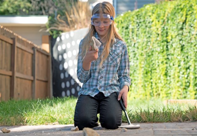 Child cracking open a geode to reveal crystals inside