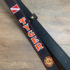 Black radio strap with orange paint, white outline and orange stitching