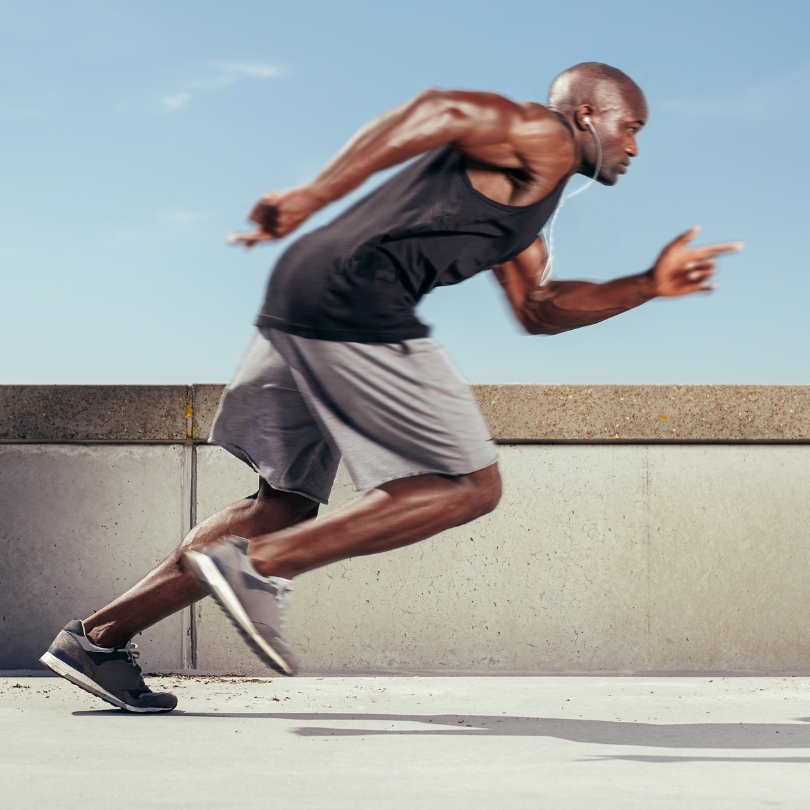 A runner, wearing running shorts, in mid dash