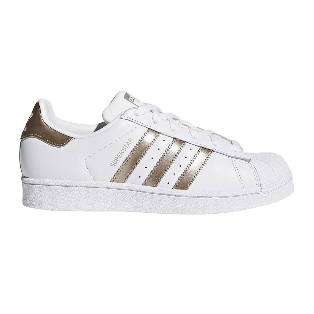 a white and gold pair of Adidas Superstar shoes, positioned on a plain white background