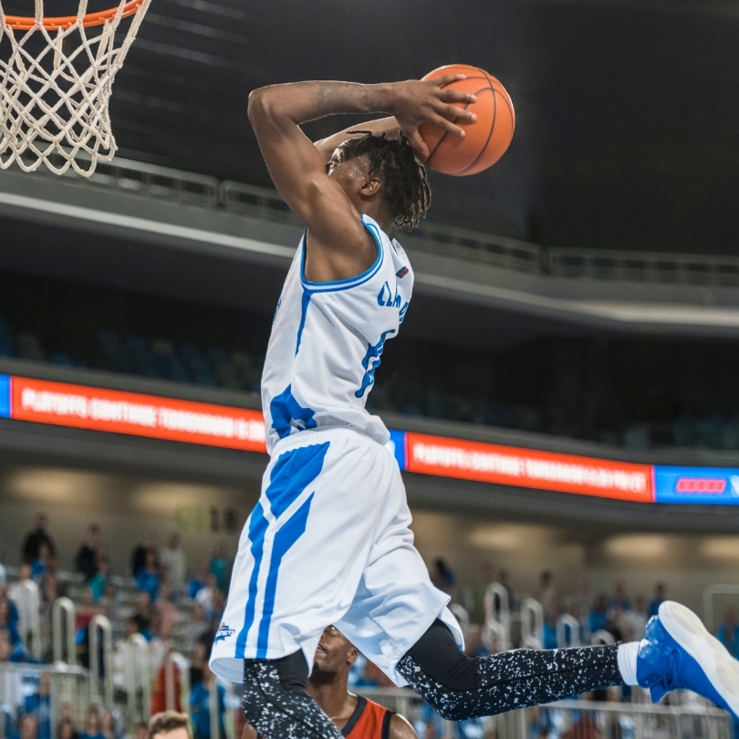 A College Basketball Player hanging in the air mid dunk