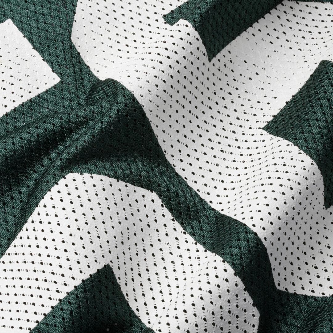 A green and white football practice jersey, folded and ready to wear.