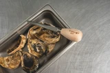 4" oyster knife on top of a pan of oysters