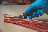 5" curved boning knife slicing beef