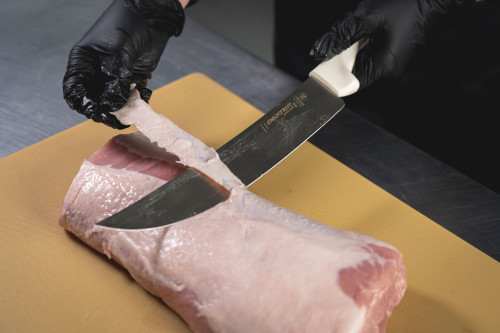 cimeter knife slicing the fat off a pork loin