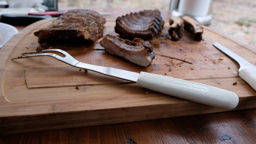 SANI-SAFE® 13" Cook's Fork laying on cutting board in front of ribs