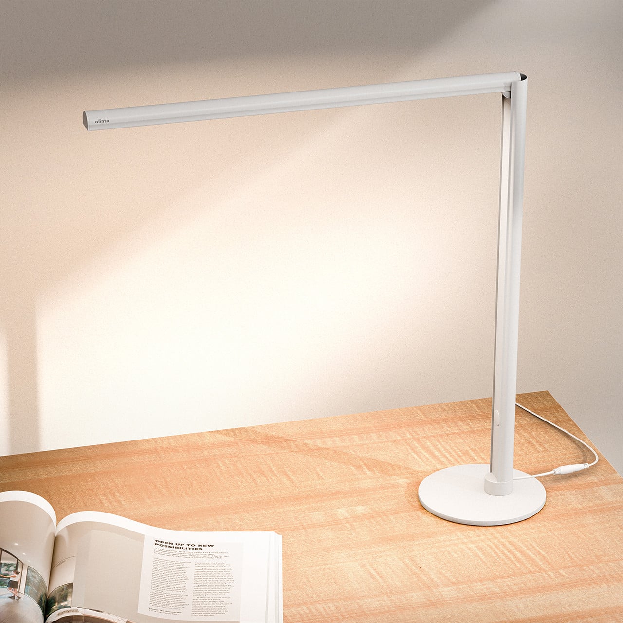 ofinto Tischlampe Lumino Desk Weiss mit Standfuss - LED-Schreibtischlampe auf Holztisch mit offener Zeitschrift, moderne minimalistische Arbeitsplatzbeleuchtung