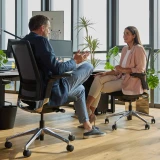 Zwei Arbeitskollegen diskutieren im Grossraumbüro auf Ergonomischen Bürostühlen Active in der Farbe Schwarz-Aluminium