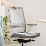 Weisser Ergonomischer Bürostuhl Active an einem Bürotisch in einem modernen Homeoffice