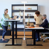 ofinto Stehlampe Lumino Weiss im modernen Büro - LED-Standleuchte beleuchtet zwei Arbeitsplätze mit höhenverstellbaren Schreibtischen Elevate in Schwarz, ergonomische Arbeitsplatzbeleuchtung für Teamarbeit mit schwarzem Regalsystem im Hintergrund