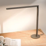 ofinto Tischlampe Lumino Desk Graphite mit Standfuss - LED-Schreibtischlampe auf Holztisch mit offener Zeitschrift, moderne minimalistische Arbeitsplatzbeleuchtung