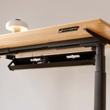 ofinto Kabelmanagement-System Schwarz geöffnet am höhenverstellbaren Schreibtisch Elevate - Detailaufnahme der weissen Kabelwanne unter FSC-zertifizierter Holztischplatte