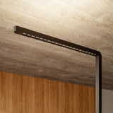 Büro-Stehlampe Lumino Pro in Schwarz, Detailaufnahme LED-Leuchtarm vor Holzverkleidung