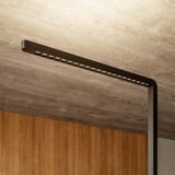 Büro-Stehlampe Lumino Pro Duo in Schwarz, Detailaufnahme LED-Leuchtarm vor Holzverkleidung