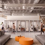 Telefonbox Focus Meet mit Möbel, in offenem Loungebereich mit Industriedecke, grauen Sofas und orangen Couchtischen