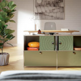Cubox Sideboard mit Soft Panel Moosgruen, ruhiges Wohnzimmer mit orangem Sitzkissen und Vase