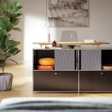 Cubox Sideboard mit Soft Panel Granitgrau, warmes Wohnzimmer mit orangem Sitzkissen und Vase