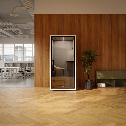 Focus Call phone booth with furniture in a modern office featuring wood paneling, hardwood floors, and a plant