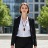 Woman wearing the Carnelian Radiance necklace with carnelian beads and a wire-wrapped pendant, styled with a white blouse and black blazer in an outdoor city setting.